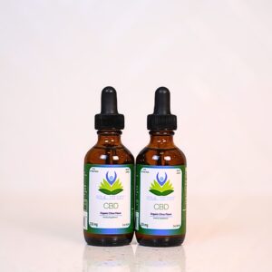 Two bottles of cbd oil sitting on top of a table.