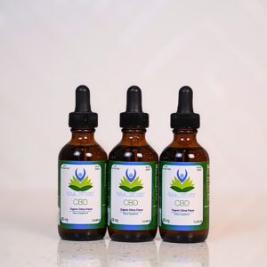 Three bottles of cbd oil sitting on a table.